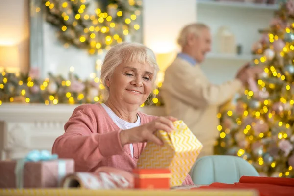 Starsi dorośli przygotowują prezenty świąteczne i dekorowanie choinki — Zdjęcie stockowe