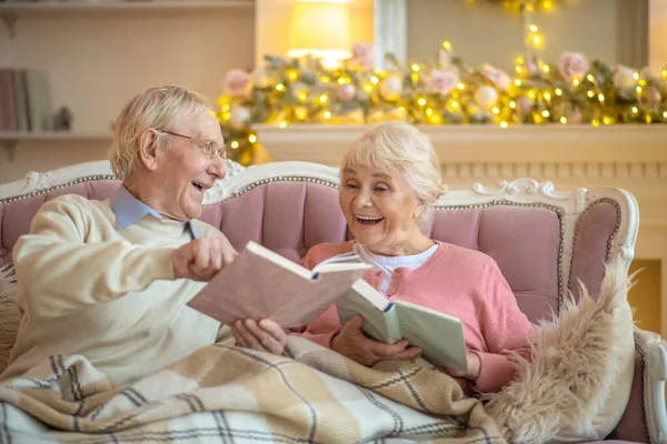 Az idősebb pár könyveket olvas és együtt nevetnek. — Stock Fotó
