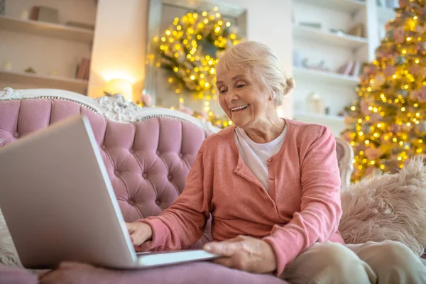 Starsza kobieta ma wideo telefon i uśmiecha się ładnie — Zdjęcie stockowe