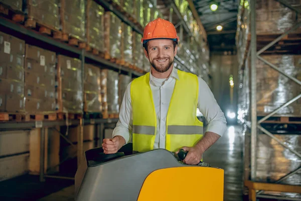 Trabajador de almacén en casco naranja trabajando y buscando satisfecho — Foto de Stock