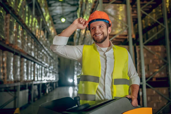 Trabajador de almacén en casco naranja trabajando y sintiéndose bien — Foto de Stock