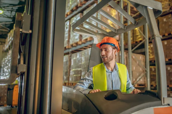 Joven trabajador barbudo de pie en el pasillo y mirando concentrado — Foto de Stock