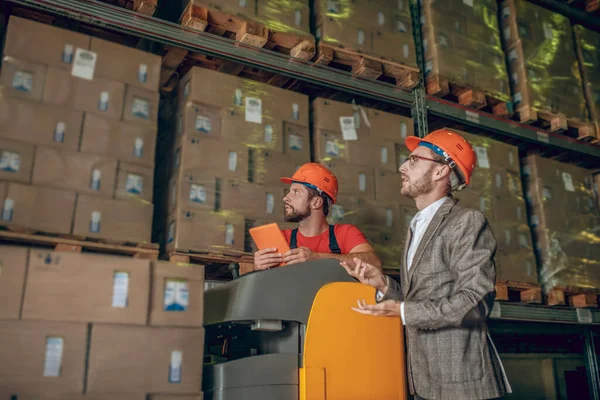 Trabajador de almacén y gerente mirando a los contenedores entregados — Foto de Stock