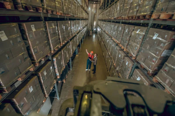 Dos personas en megastore con muchos contenedores en los estantes — Foto de Stock
