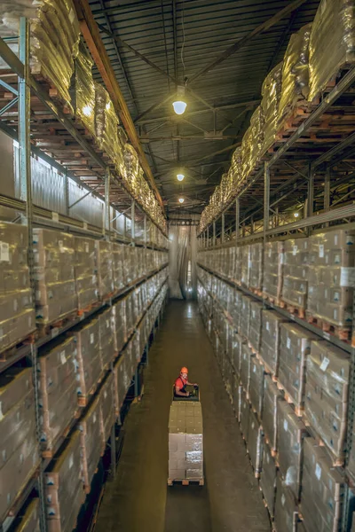Trabajador de almacén va entre los estantes en un almacén — Foto de Stock