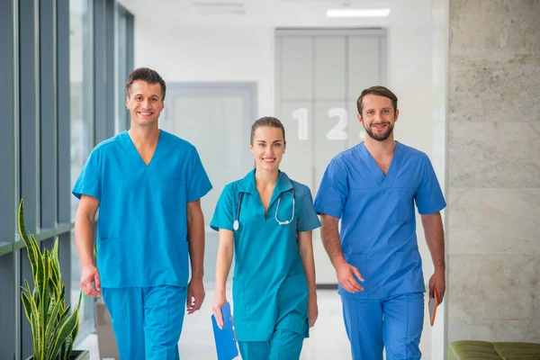 Three doctors walking together in the hospital corridor