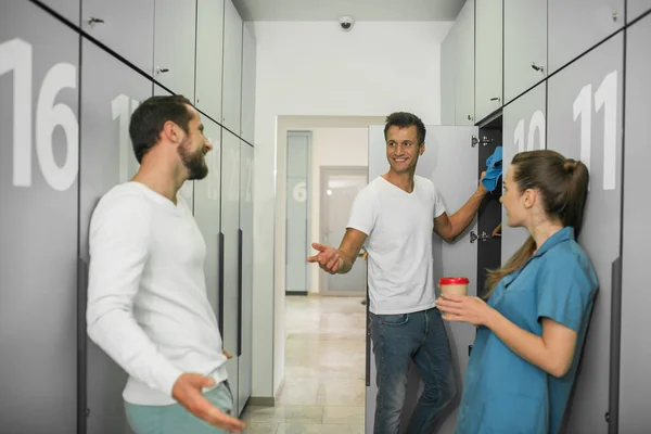 Group of people standing in the changing room and talking — Stock Photo, Image