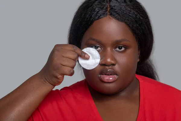 Młoda kobieta o ciemnej skórze trzyma gąbkę do oczyszczania twarzy — Zdjęcie stockowe