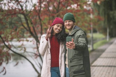Kadın ve erkek birlikte sonbahar selfie 'si çekiyorlar.