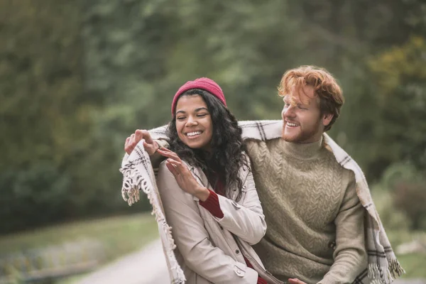 Man covering his girlfriend with a warm plaid — Stock Photo, Image