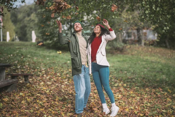 Mann und Frau fangen Herbstlaub bei windigem Wetter — Stockfoto