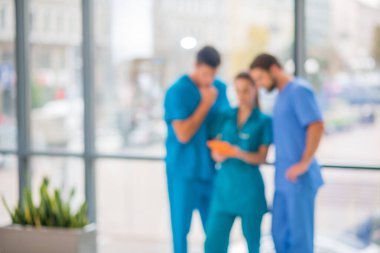 Bir grup doktor tabletten bir şey izliyor ve ilgileniyorlar.