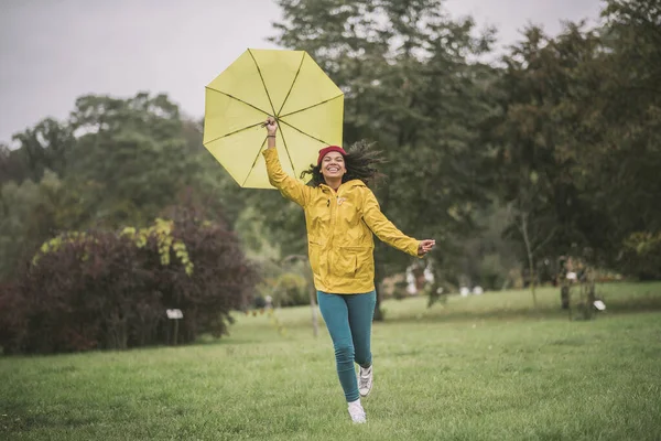 黄色の傘が走っていて楽しいですかわいいマラタ — ストック写真