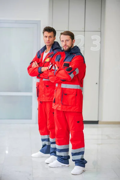 Dos trabajadores médicos en uniforme rojo de pie en el pasillo — Foto de Stock