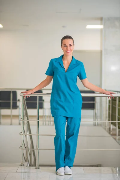 Doctora joven en uniforme azul de pie en las escaleras — Foto de Stock