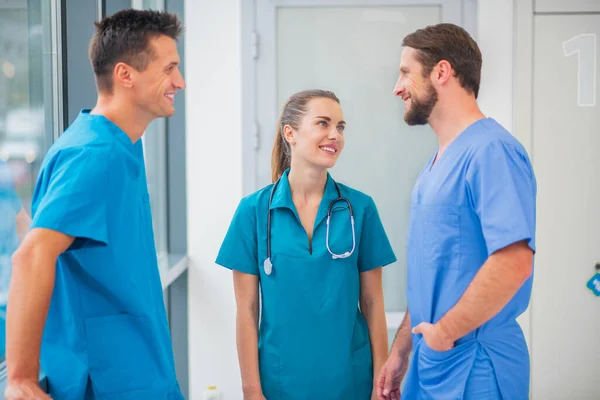 Grupo de médicos conversando no corredor e sentindo-se positivo — Fotografia de Stock