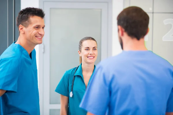 Grupo de médicos hablando en el pasillo y sintiéndose emocionados — Foto de Stock