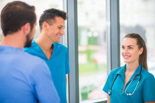 Grupo de médicos hablando en el pasillo y sintiéndose emocionados — Foto de Stock