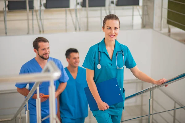 Tres médicos que tienen una jornada laboral en la clínica y se ven confiados — Foto de Stock