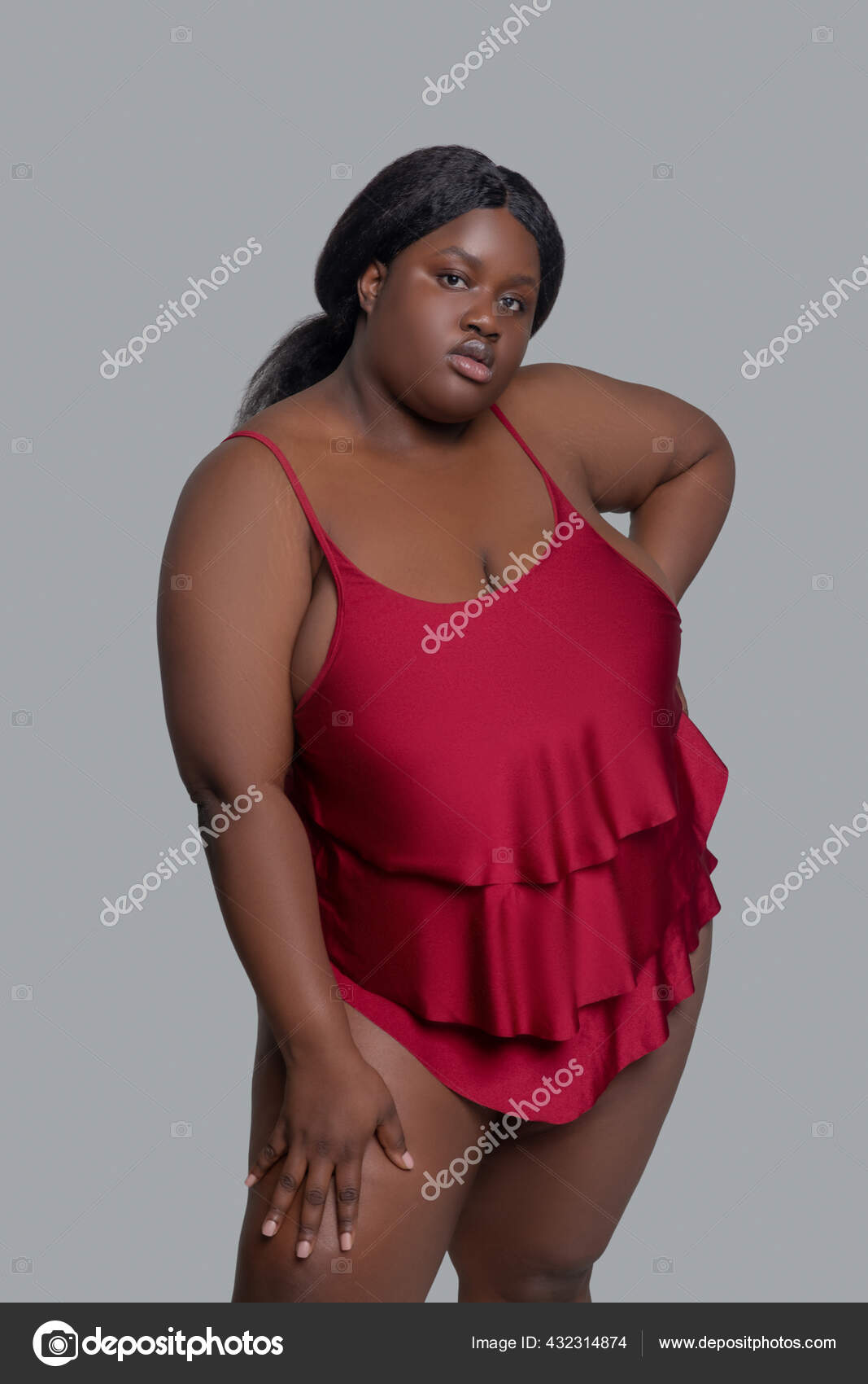 Plus size african american young woman in red underwear posing