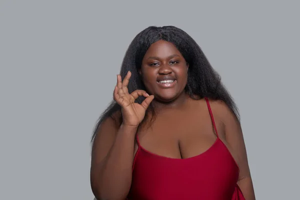 Afrikansk amerikansk ung kvinna i röda underkläder visar ok tecken — Stockfoto