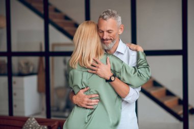 Erkek ve kadın birbirlerine sarılıyorlar ve mutlu hissediyorlar.