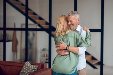 Erkek ve kadın birbirine sarılıyor ve mutlu görünüyorlar.