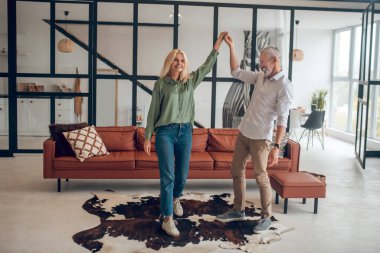 Kadın ve erkek odada dans ediyor ve iyi hissediyorlar.