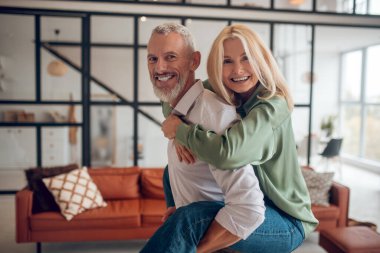 Adam karısını sırtında tutuyor ve kendini harika hissediyor.