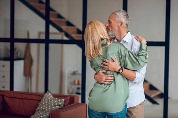 Homem e mulher abraçando uns aos outros e parecendo felizes — Fotografia de Stock