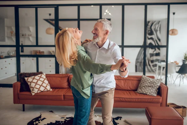 Nice couple dancing in the room and looking happy — Stock Photo, Image