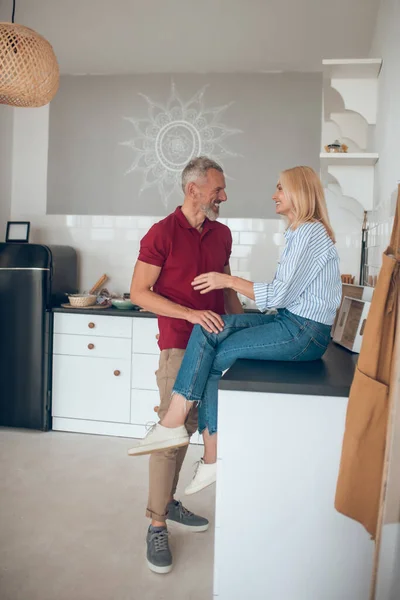 Мужчина и женщина разговаривают на кухне и выглядят вовлеченными — стоковое фото