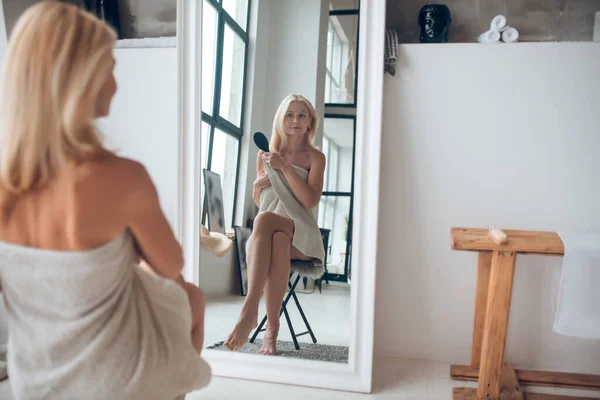 Pretty blonde woman looking in the mirror — Stock Photo, Image