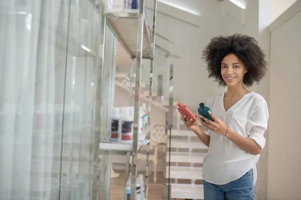 Junge Frau im Schönheitszentrum wählt Kosmetik — Stockfoto