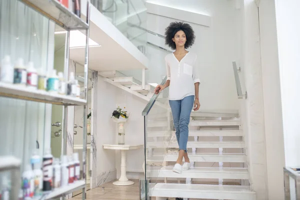 Joyful young woman on steps in beauty center — 图库照片