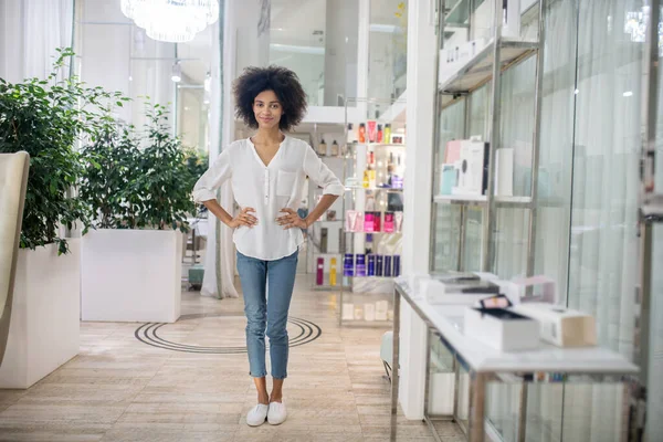 Slim leende flicka står i lobbyn av skönhetscenter — Stockfoto