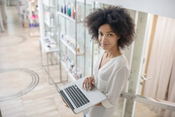 Flicka med lockigt hår med öppen laptop — Stockfoto