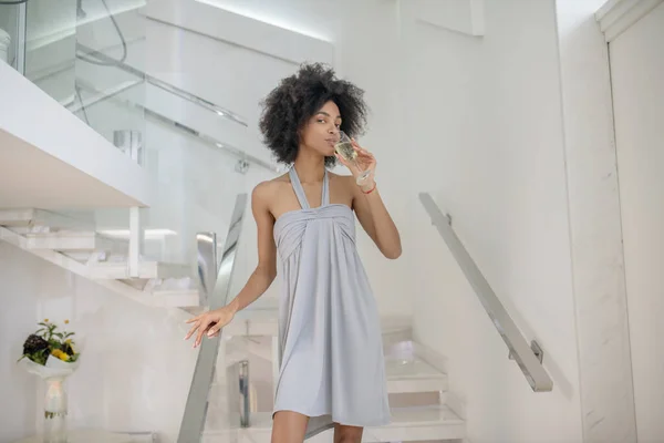 Young pretty woman with drink on white stairs — Stock Photo, Image