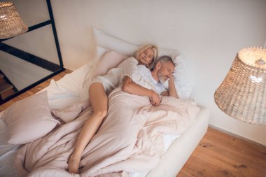 Evli çift bir yatakta huzur içinde uyuyor.