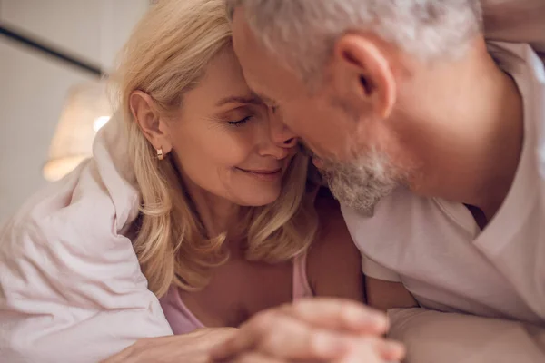 Middle-aged couple having romantic moment in bedroom — Stock Photo, Image