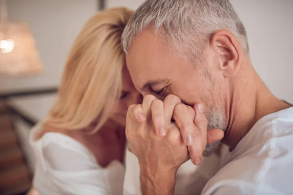 Hombre sosteniendo su mano de mujer y buscando romántico — Foto de Stock