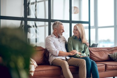 Olgun bir çift kanepede oturup güzel güzel sohbet ediyor.