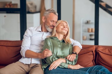 Olgun bir çift kanepede oturuyor ve huzurlu hissediyorlar.