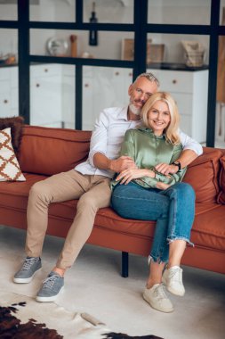 Olgun bir çift kanepede oturuyor ve huzurlu hissediyorlar.