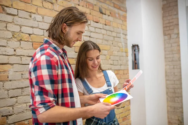 Νεαρό ζευγάρι συζητά το χρώμα για τους τοίχους — Φωτογραφία Αρχείου