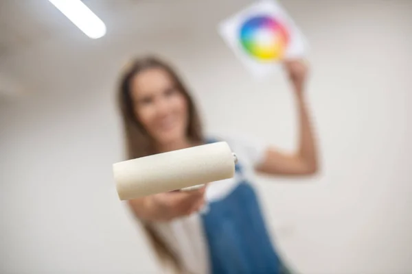 Young woman holding a color palette and a paint roller — Stock Photo, Image