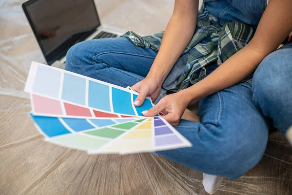 Primer plano de la gente sentada en el suelo y discutiendo la paleta de colores — Foto de Stock