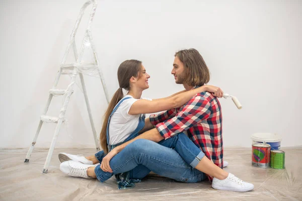 Счастливая пара сидит на полу и обнимает друг друга — стоковое фото