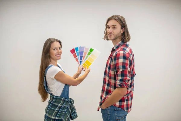 Pareja joven de pie en la pared en una casa nueva — Foto de Stock