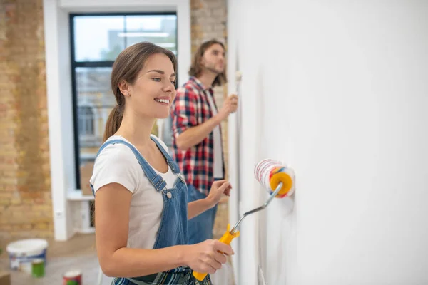 Young couple painting wall in their new house — Stock Photo, Image